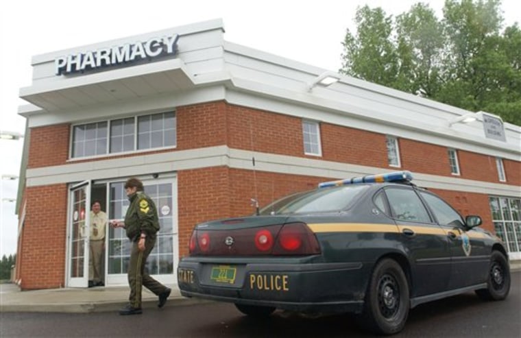 FILE In this file photo of June 3, 2006, Vermont State Police trooper Betsy Trombley investigates the scene of an armed robbery at McGregor's Pharmacy in South Hero, Vt., after a  masked man allegedly put a gun to the head of a customer, forced several people including employees to lay on the ground, and threatened to shoot them before stealing a quantity of drugs and escaping in a car with a female getaway driver. From Redmond, Wash. to St. Augustine, Fla., criminals are holding pharmacists at gunpoint and escaping with thousands of powerfully addictive pills that can sell for up to $80 apiece on the street.  ( AP Photo/Rob Swanson, File)